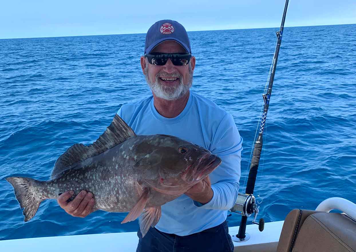 Off-shore fisherman with large grouper fish caught aboard Dahl-Fins fishing charters