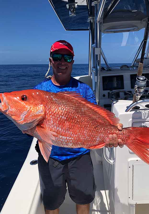 Fishing charter customer with large red snapper catch in Southwest Florida
