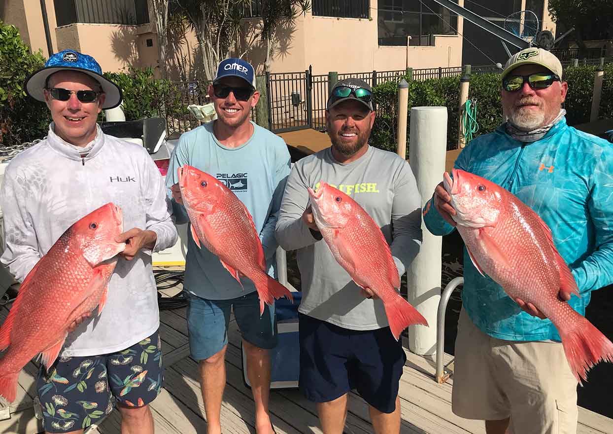 Group of fishing charter clients with red snapper fish caught in Southwest Florida
